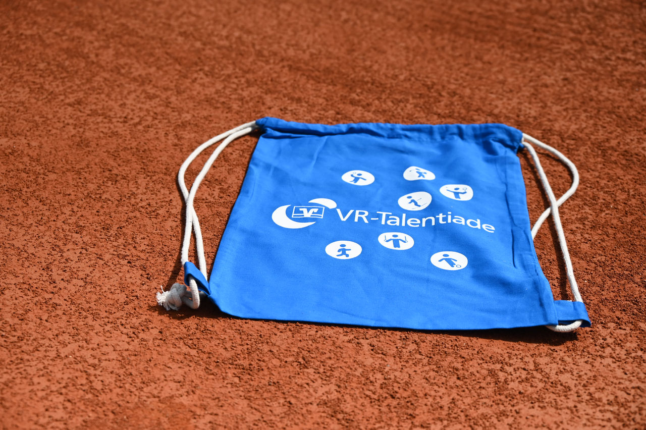 Blaue Tasche mit VR-Talentiade-Logo liegt auf dem Sandplatz