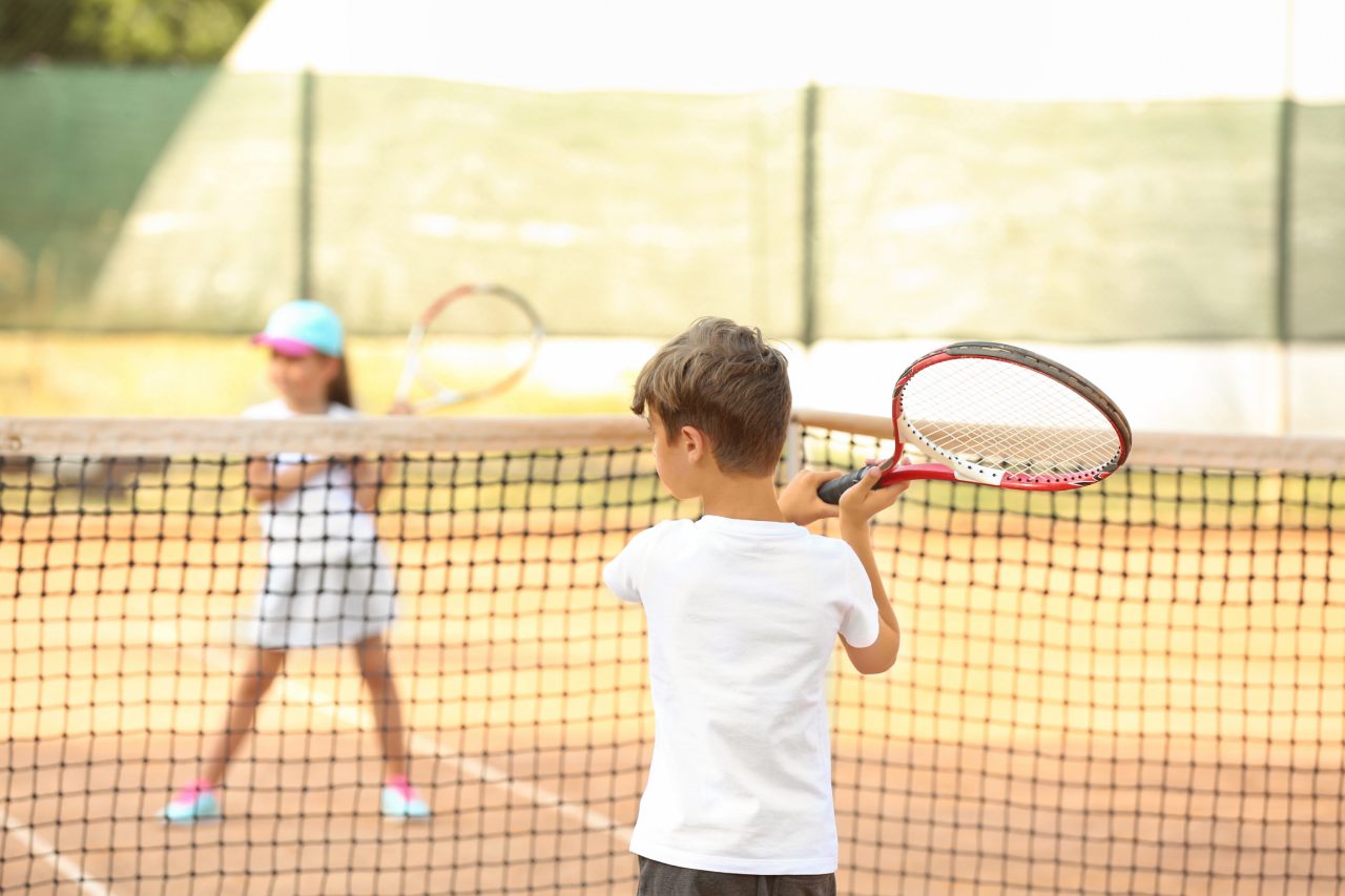 zwei Kinder spielen Tennis